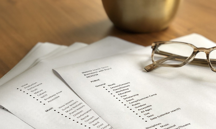 papers with list of categories printed and pair of glasses on top